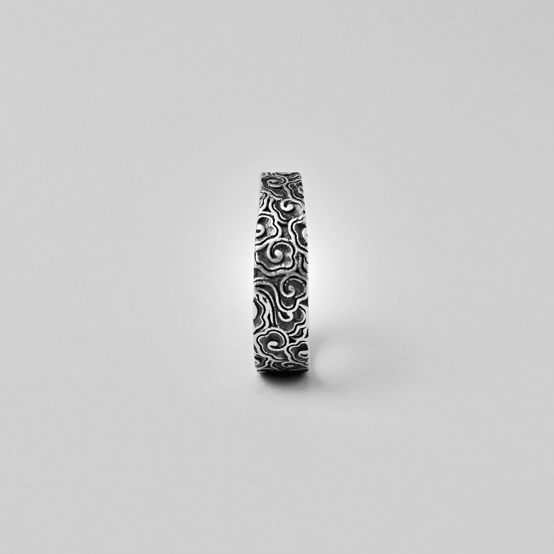 Close view of repeating Chinese auspicious cloud patterns on a 999 fine silver adjustable ring